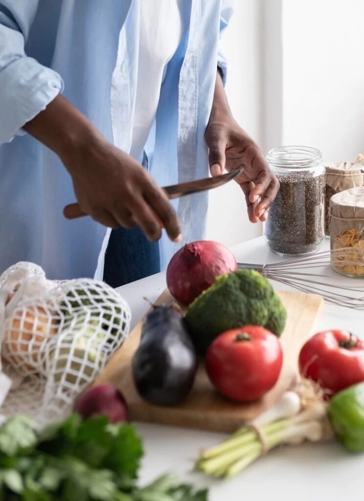 Main de femme en train de coupé des légume sur une table
