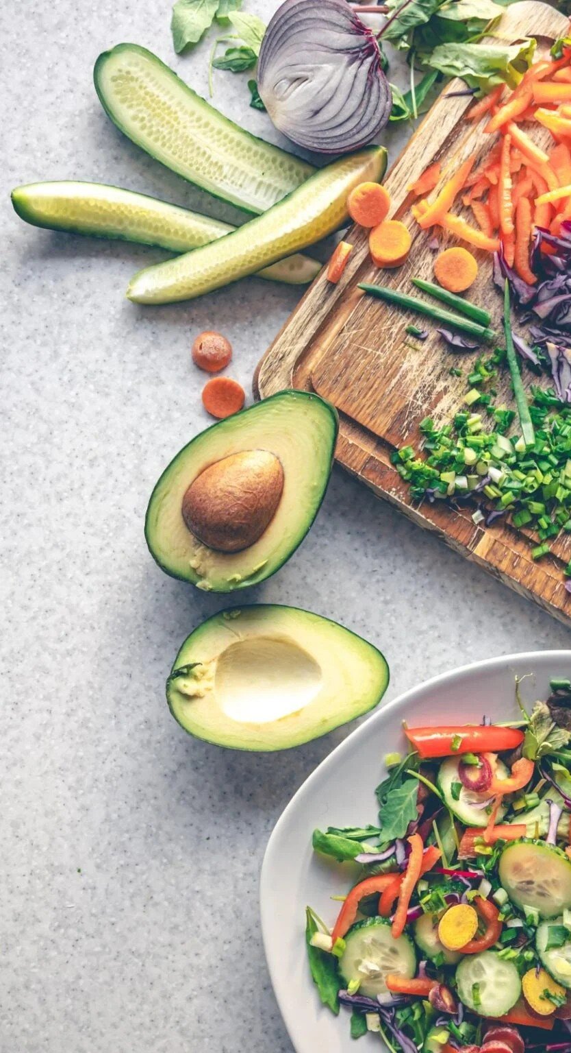 avocat coupé et autre légumesur une table